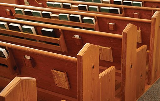 Wooden church pews with hymnals, creating a serene atmosphere for worship.
