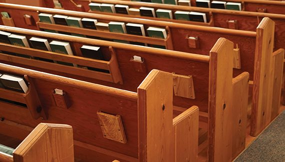 Wooden church pews with hymnals, creating a serene atmosphere for worship.