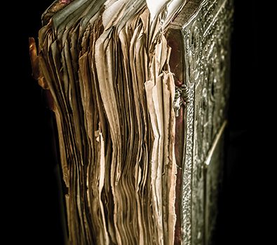 Antique leather-bound book with ornate cover, worn pages, and metallic clasps, evoking history and mystery.