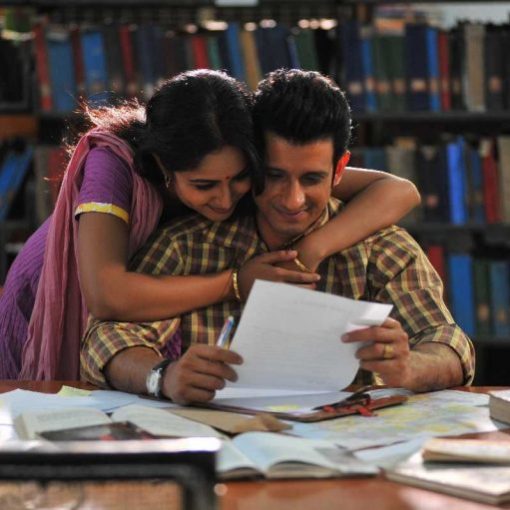 Couple reading together in library, smiling, surrounded by books.