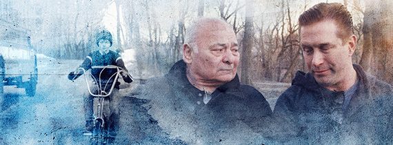 A boy riding a bike, while two men share a thoughtful moment in a misty, scenic background.