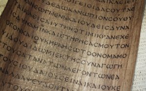 Ancient Greek manuscript on papyrus scroll with Greek letters, showcasing historical text and cultural heritage, close-up view.