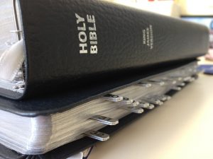 Close-up of a Holy Bible with thumb index tabs on a table, highlighting its detailed and organized sections.