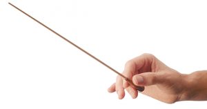 Hand holding a conductor's baton, isolated on white background.