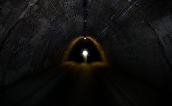 Dark tunnel interior with a bright light at the exit, symbolizing hope and new beginnings.